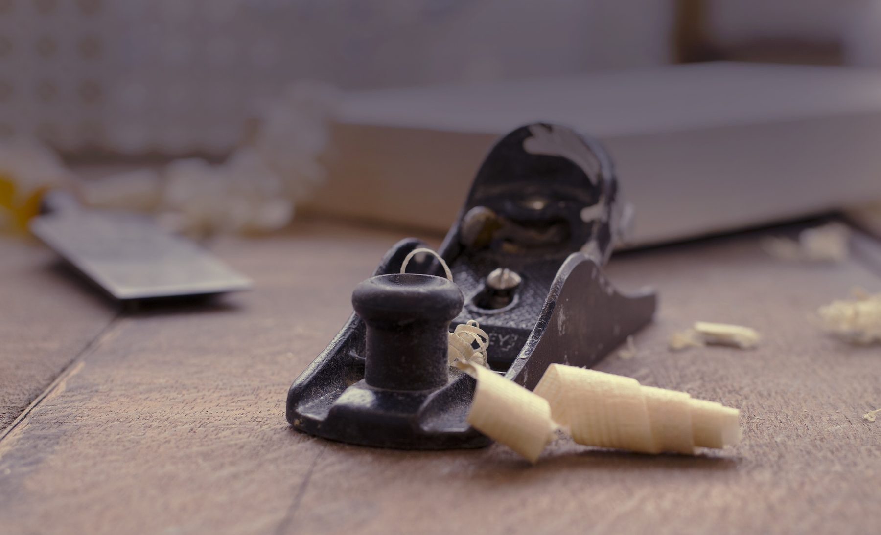 Una pialla a mano con un truciolo arricciato sul legno